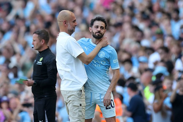 Pep Guardiola embraces Bernardo Silva as he leaves the pitch whilst being substituted.