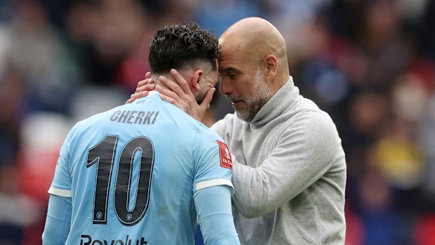 Manchester City's head coach Pep Guardiola celebrates with Rayan Cherki.
