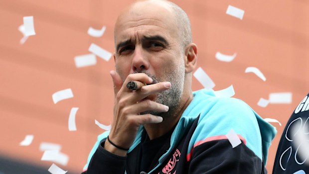 Pep Guardiola smokes a cigar.