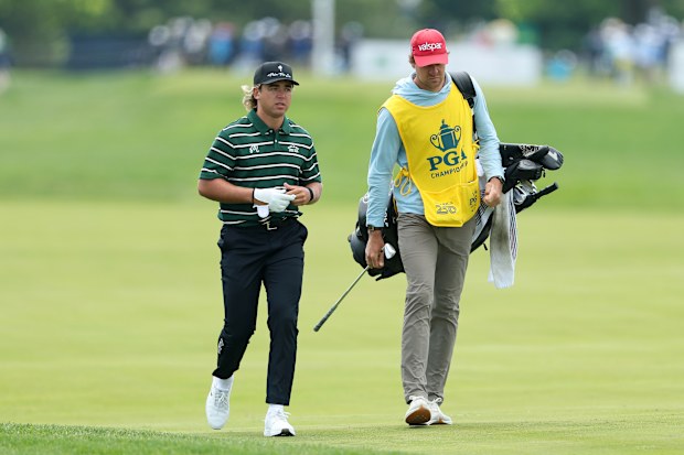 Garrick Higgo of South Africa walks the 16th hole alongside caddie Austin Gaugert.
