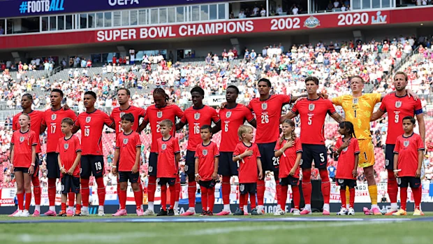 Players of England line up on the pitch.